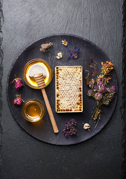 istock honey and dried herbs on a stone black background 484151858