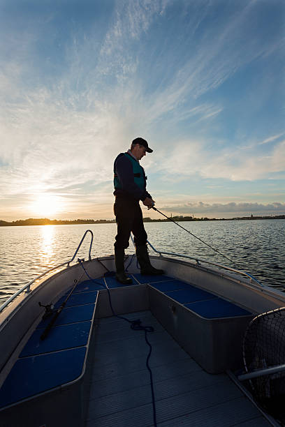 istock Fisherman Waiting For a Bite On His Line at Sunset 484155034