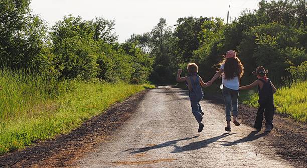 istock Country Kids Running Down Dirt Road 484155106