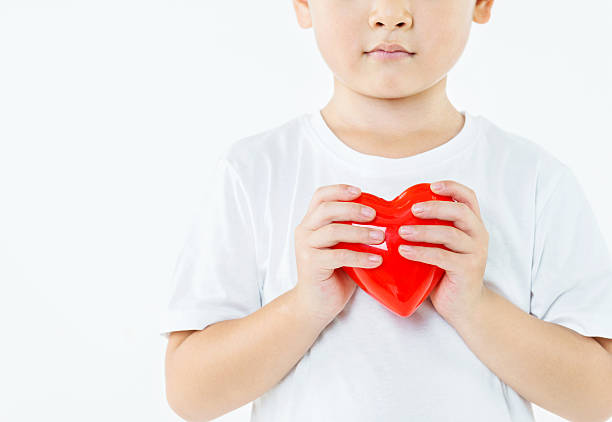 Portrait of cute showing hand heart gesture, sweet precious child making body language, love, positive feeling and emotion