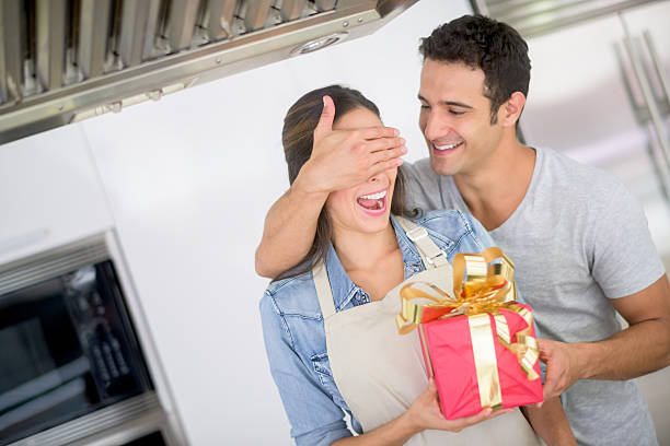 Free Stock Photo of Man presenting flowers and a gift to his partner as ...