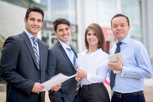 Group of successful Latin American business people outside an office building and smiling