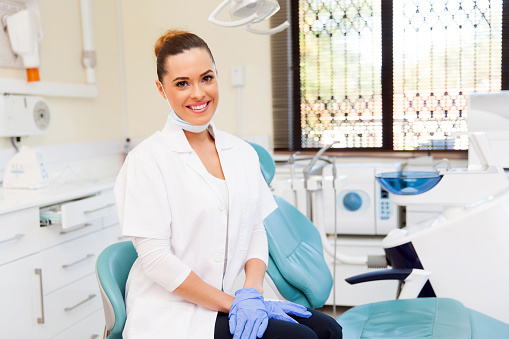 portrait of young female dentist in office