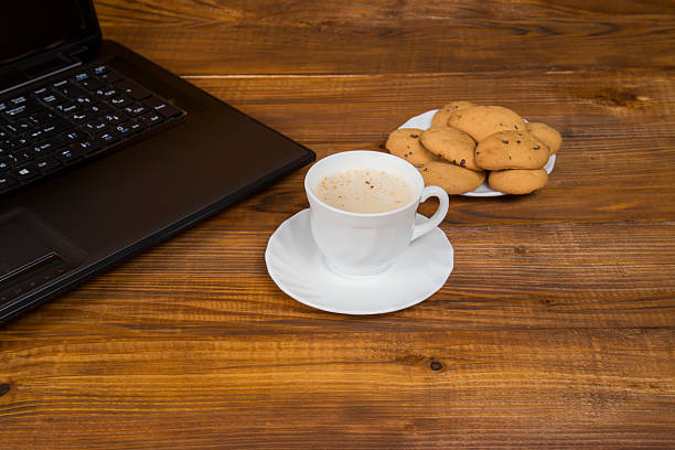 istock computer a cup of coffee and cookies 484163158