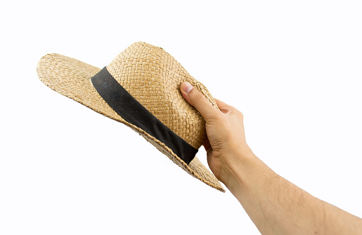 hand holding a straw hat isolated on white background