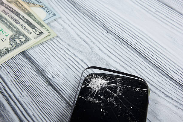 istock Modern broken mobile phone and money on white wooden background. 484164152