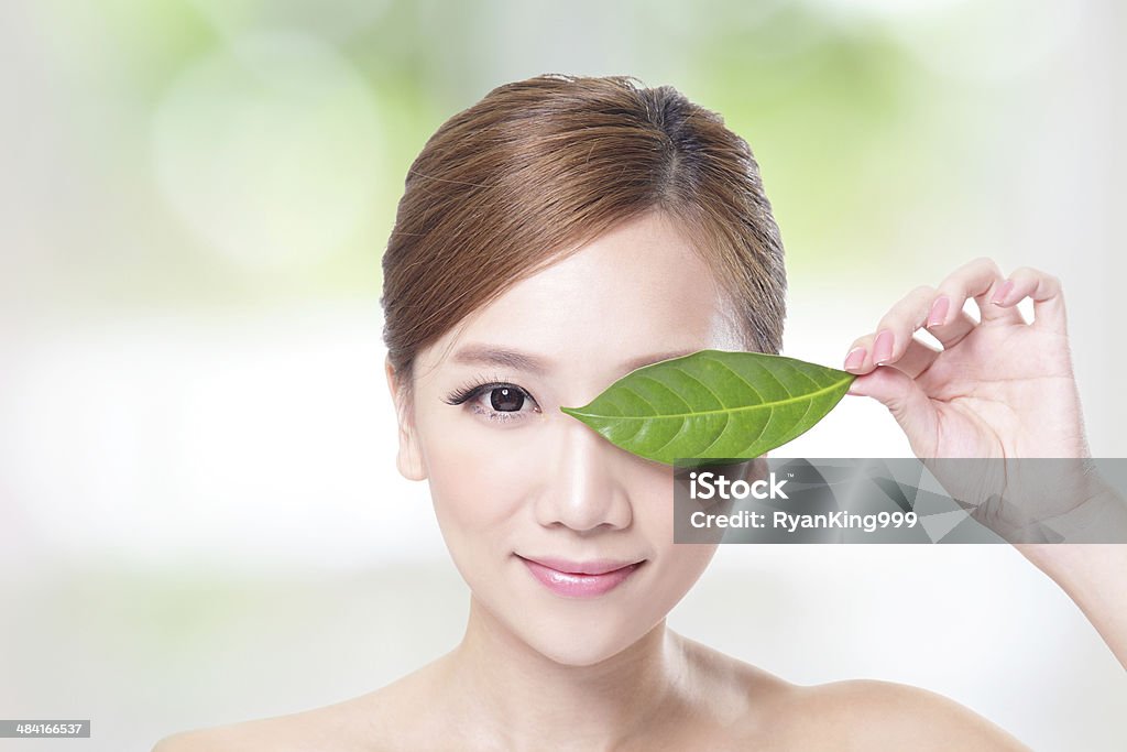 beautiful woman face portrait with green leaf woman face portrait with green leaf , concept for skin care or organic cosmetics , asian beauty Adult Stock Photo