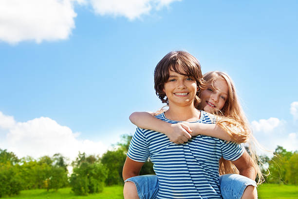 Boy and girl piggyback Happy couple of kids in the park with boy carry girl piggyback 10 11 years photos stock pictures, royalty-free photos & images