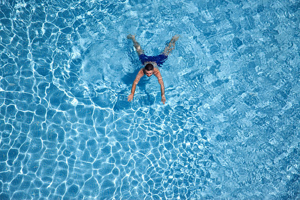 istock Young man swimming in the pool 484167734