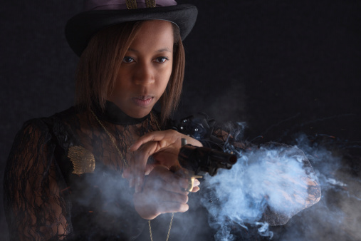 Tough Steampunk female caught by the camera as she fires her revolver.