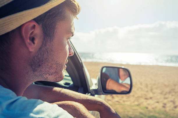 istock Man in car looking at the beach 484168345