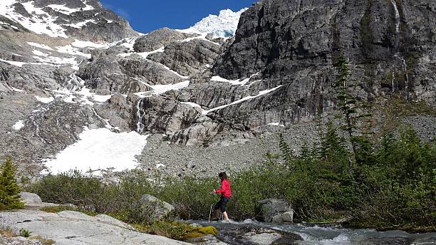 istock Young woman hiker crossing a cold mountain stream 484168656