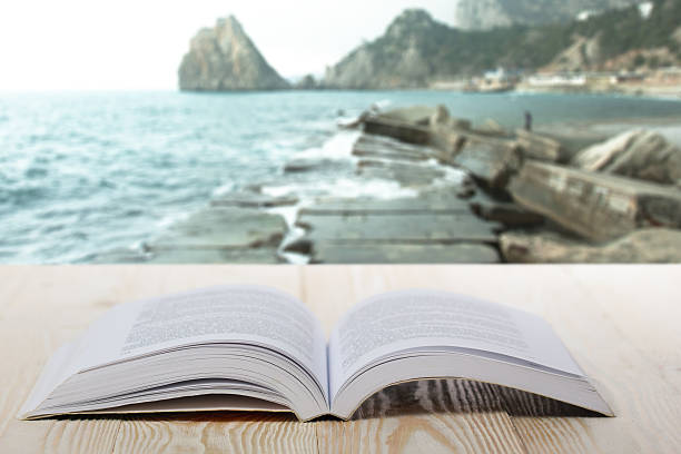istock Open book on wooden table on natural blurred background 484170272