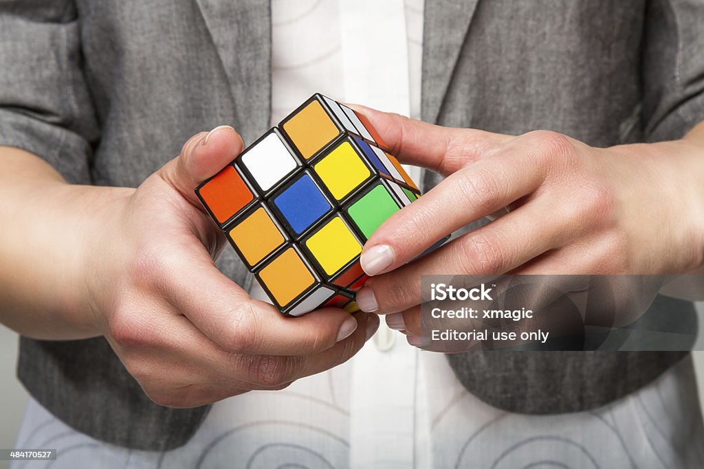 Hands holding color cube Minsk, Belarus - March 24, 2011: Hands holding or playing color cube game for concept solve solutionsolding color cube. Shot in a studio setting. Rubik's Cube is a 3D mechanical puzzle invented in 1974 by Hungarian sculptor and professor of architecture Erno Rubik Puzzle Cube Stock Photo