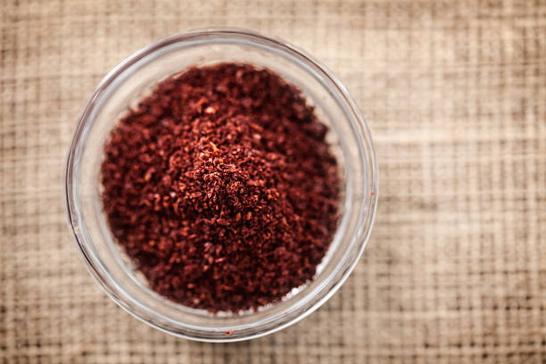 Sumac - somaq Oriental cuisine: Ground sumac (somaq) powder in small glass bowl; close up; sumac spice stock pictures, royalty-free photos & images