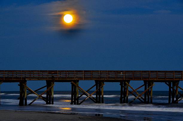 istock moonrise over the pier 484170847