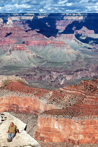Tourists sitting on the edge of the Grand Canyon Arizona, clear afternoon after rain, Arizona, USA.Nikon D3x