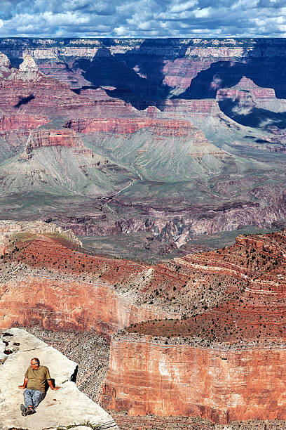 turistas sentado na borda do grand canyon no arizona - at the edge of fotos - fotografias e filmes do acervo