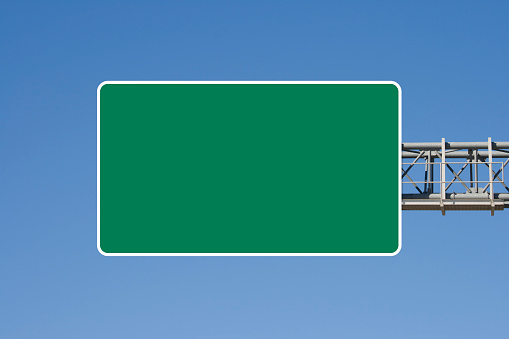 Empty highway sign set against blue sky