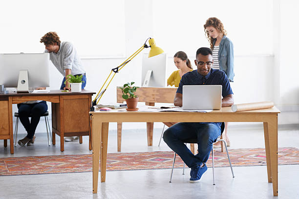 Modern business: Young, trendy and totally creative! Shot of a group of young professionals working in an office small office stock pictures, royalty-free photos & images