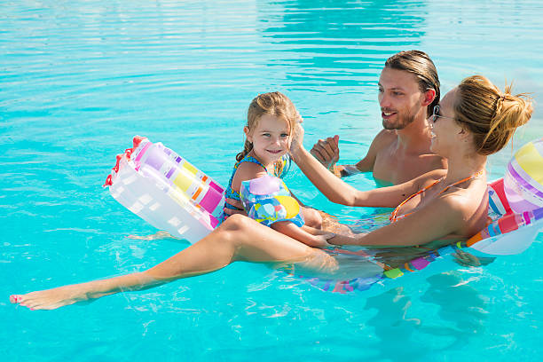 Parents and daughter enjoying in their time together at swimmingpool