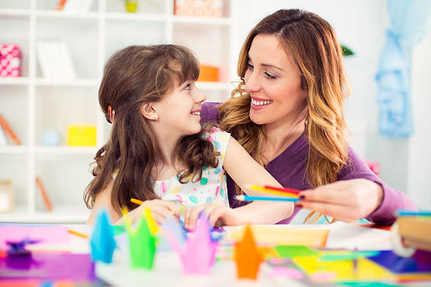 istock Mother and daughter making origami. 484191967