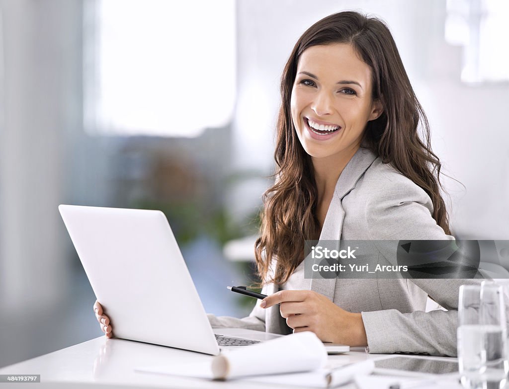 It feels great to have made it! Shot of an attractive businesswoman sitting at her desk in an office Businesswoman Stock Photo