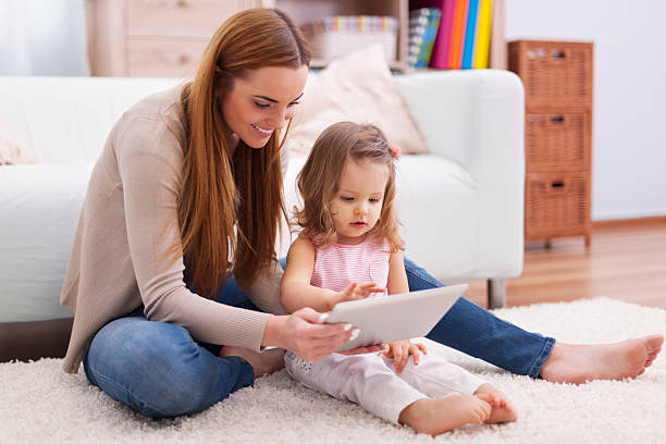 istock Young mother helping her daughter with digital tablet 484194273