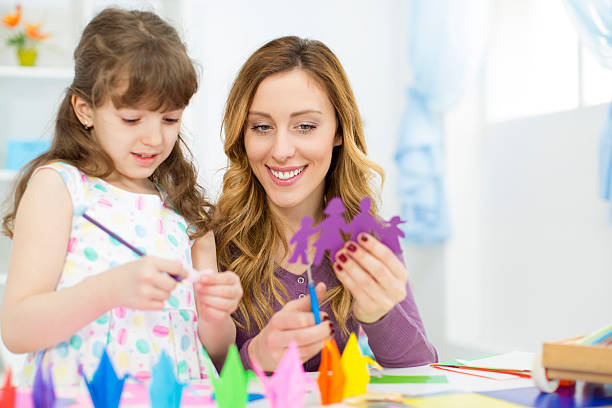 istock Mother and daughter making origami. 484194659