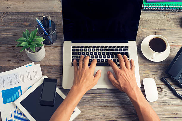 istock Wooden desk with technology and financial figures. 484195094