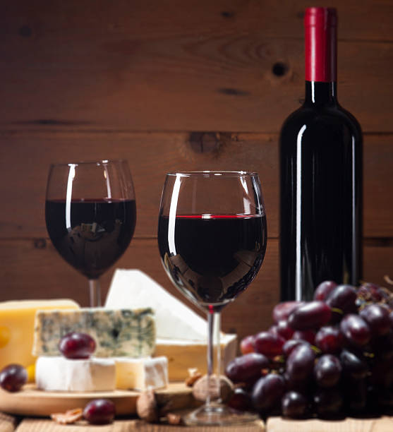 istock Red wine with various types of cheese on wooden background 484195682