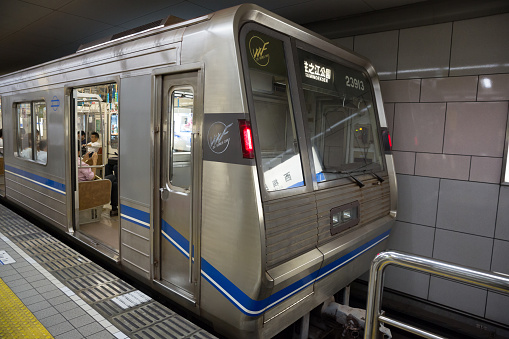 Osaka, Japan - July 28, 2014: People at Nishi-Umeda Station in Osaka Prefecture, Japan. This train is on Yotsubashi Line going to  \tSuminoekoen. It is operated by the Osaka Municipal Subway. 