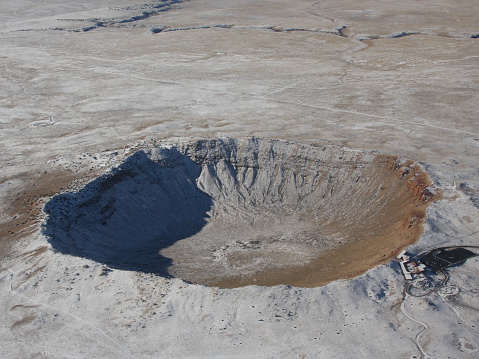 Aerial view of the Arizona Meteor Crater near Flagstaff, AZ, wintertime.  For scale, see the single bus parked on the black tarmac on the right