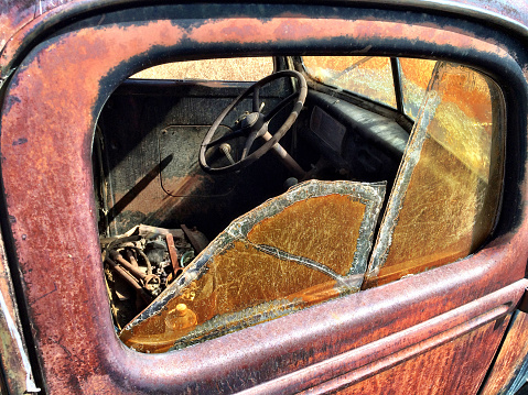 Rusted old pickup truck with broken window.