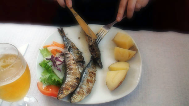 istock Eating Grilled Fish And Cooked Tomato And Salad In Restaurant 484199030