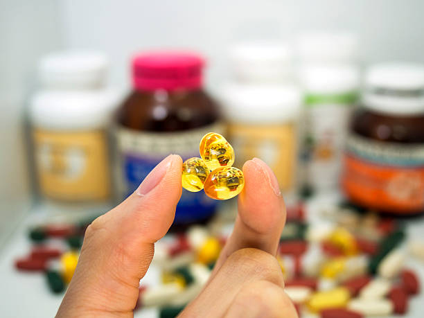 istock taking a fish oil,multivitamin,supplement capsules, fish oil 484202504