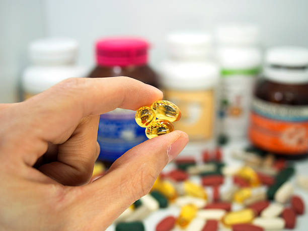 istock taking a fish oil,multivitamin,supplement capsules, fish oil 484202508