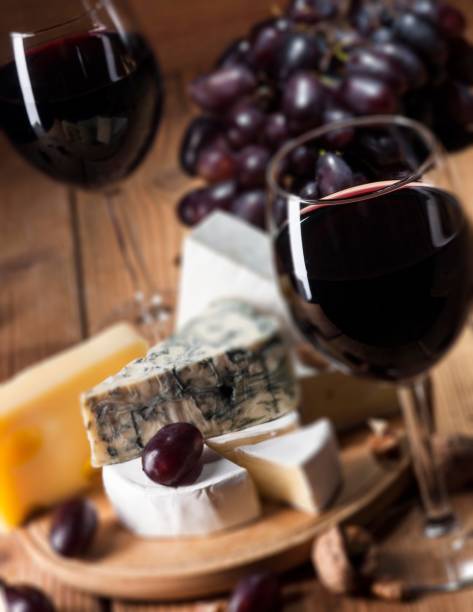 istock Red wine with various types of cheese on wooden background 484206964