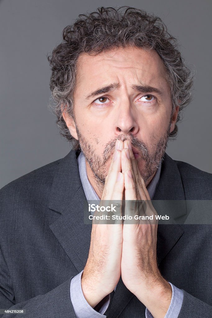 creative entrepreneur in meditation anxious businessman meditating and thinking with typical hand gesture in praying position, looking up for efficient strategy 2015 Stock Photo