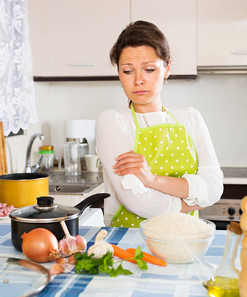 istock Pensive woman cooks rice with vegetables 484218754
