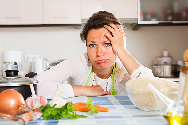 istock Pensive woman cooks rice with vegetables 484218756