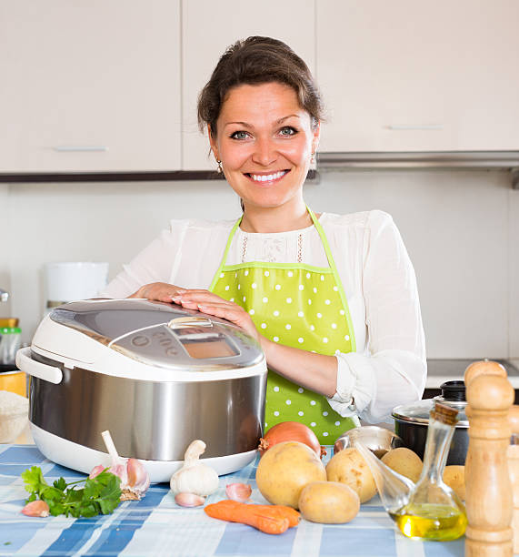 istock Housewife cooking with multicooker 484218766