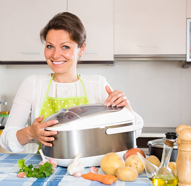 istock Housewife cooking with multicooker 484218768