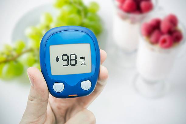 diabète faisant glucose niveau test. fruits en arrière-plan - meter diabetes blood scrutiny photos et images de collection