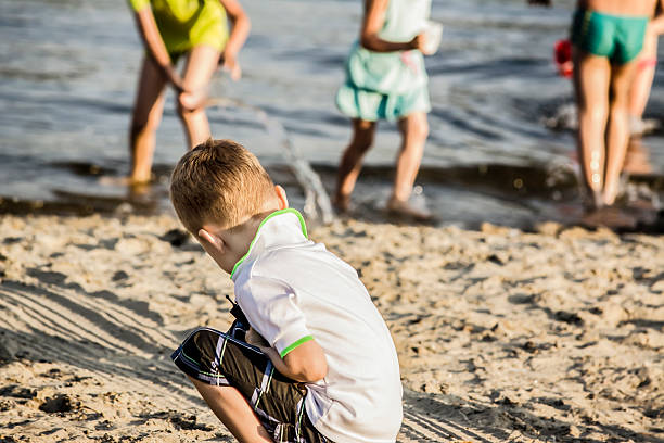 istock boy playing on the river bank in the sand 484221836