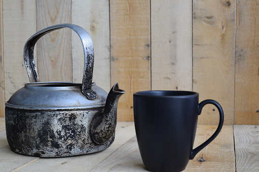 Classic kettle with black cup on wood board