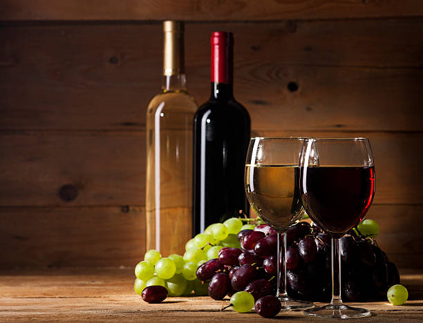 istock Red and white wine on wooden background 484224894