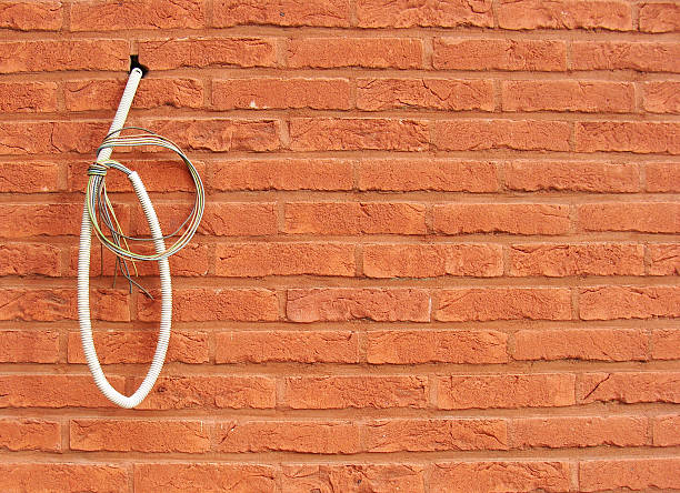 istock electricity wire hanging on red brick wall 484225833