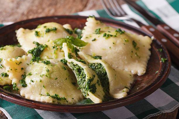ravioli with spinach and cheese close-up horizontal Italian ravioli with spinach and cheese close-up on a brown plate. horizontal, rustic style ricotta photos stock pictures, royalty-free photos & images