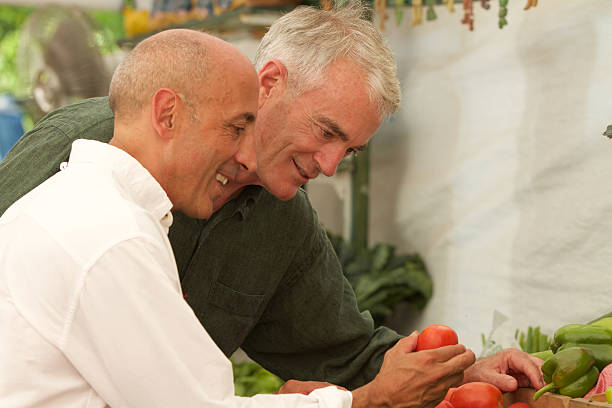 Senior Gay Male Couple Buying Produce at Farm Stand stock photo